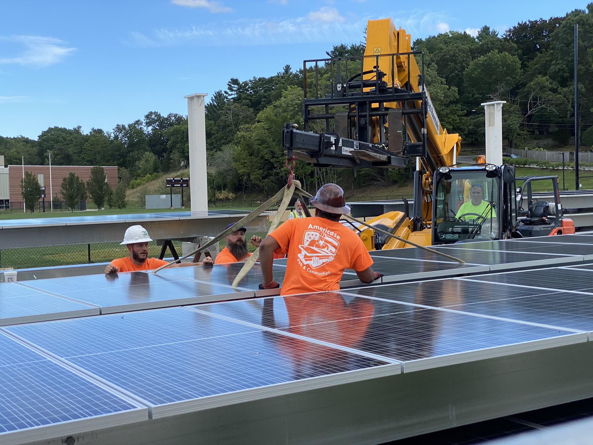 Install crew lifting solar panels into place with a crane