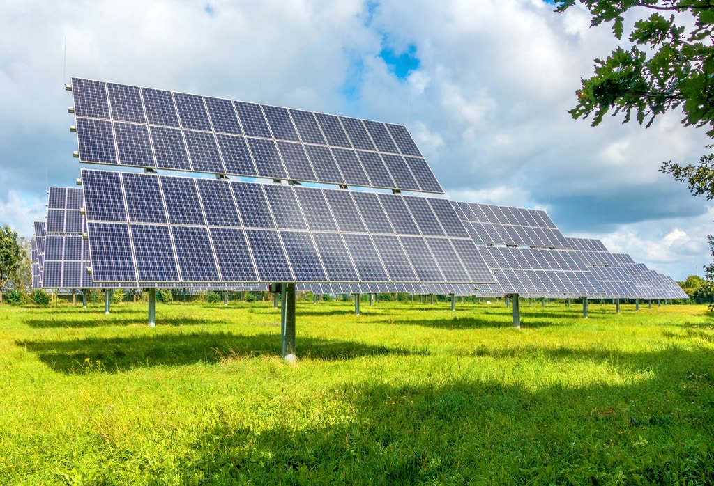 Single-axis tracking solar panels in a green meadow
